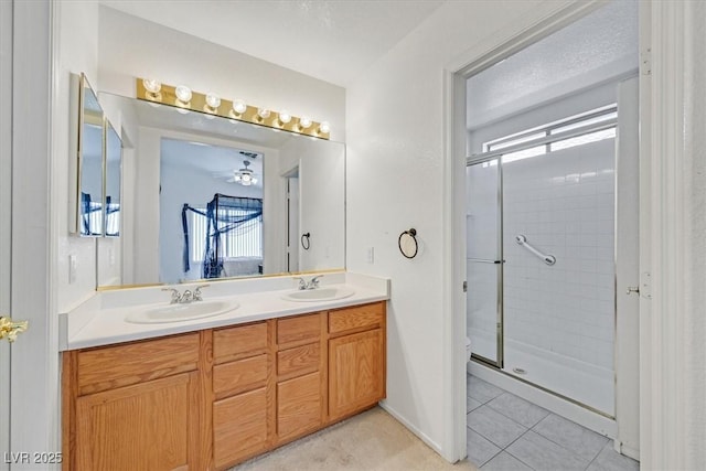bathroom with double vanity, a shower stall, and a sink