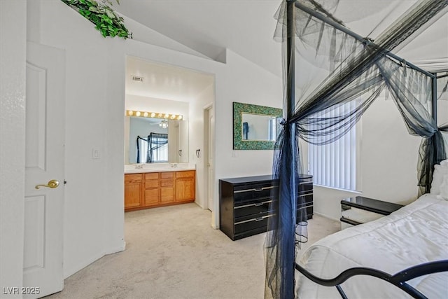 bedroom featuring baseboards, light colored carpet, ensuite bathroom, and lofted ceiling