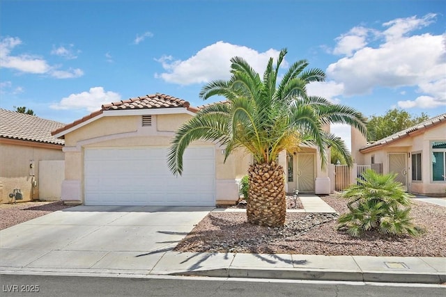 mediterranean / spanish-style home featuring a tiled roof, an attached garage, stucco siding, and driveway