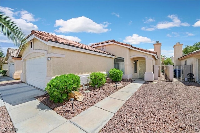 mediterranean / spanish home featuring a garage, fence, stucco siding, a gate, and a tile roof