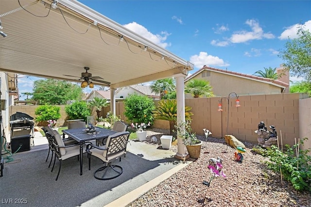 view of patio with outdoor dining area, a ceiling fan, and a fenced backyard