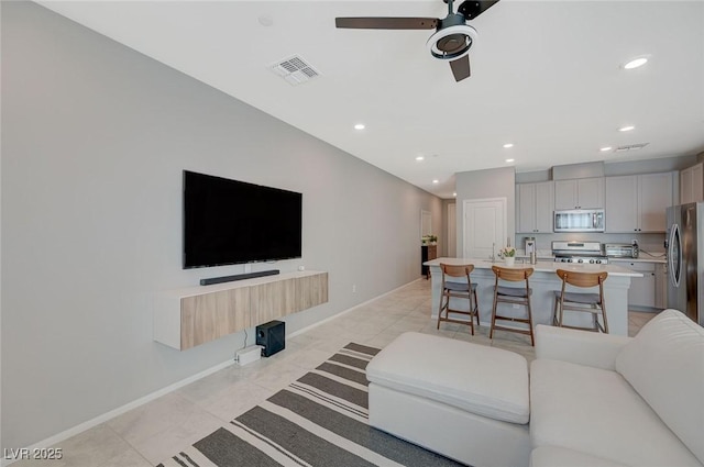 living room with visible vents, baseboards, ceiling fan, recessed lighting, and light tile patterned floors