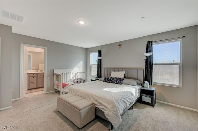 bedroom featuring connected bathroom, baseboards, visible vents, and light carpet