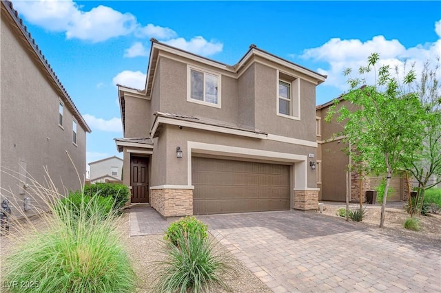 view of front of house featuring an attached garage, decorative driveway, stucco siding, and stone siding