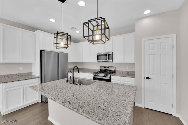 kitchen featuring a sink, appliances with stainless steel finishes, wood finished floors, and visible vents