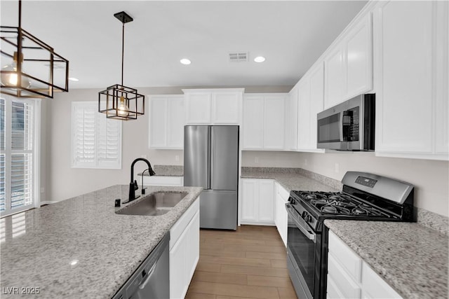 kitchen featuring visible vents, wood finished floors, a sink, stainless steel appliances, and recessed lighting