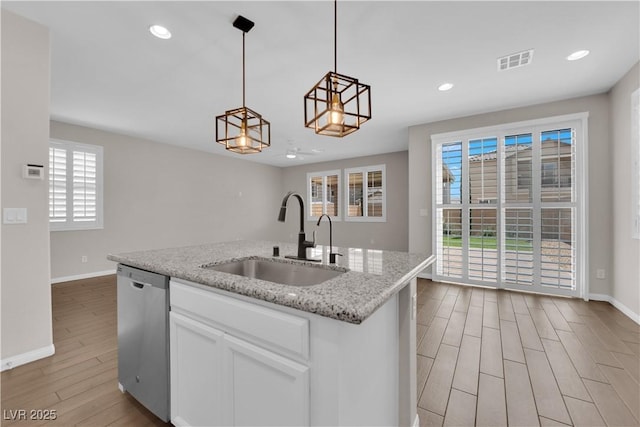 kitchen featuring visible vents, dishwasher, a sink, baseboards, and light wood-style floors