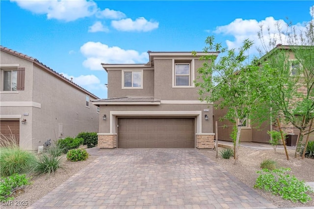 view of front of home featuring stucco siding, an attached garage, decorative driveway, and stone siding