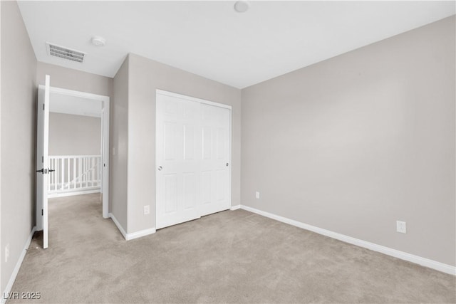 unfurnished bedroom featuring visible vents, carpet, baseboards, and a closet