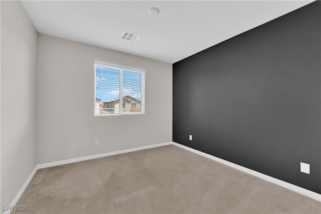 empty room with visible vents, carpet, and baseboards