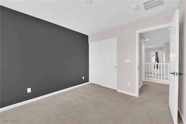 unfurnished bedroom featuring visible vents, carpet flooring, baseboards, and a closet