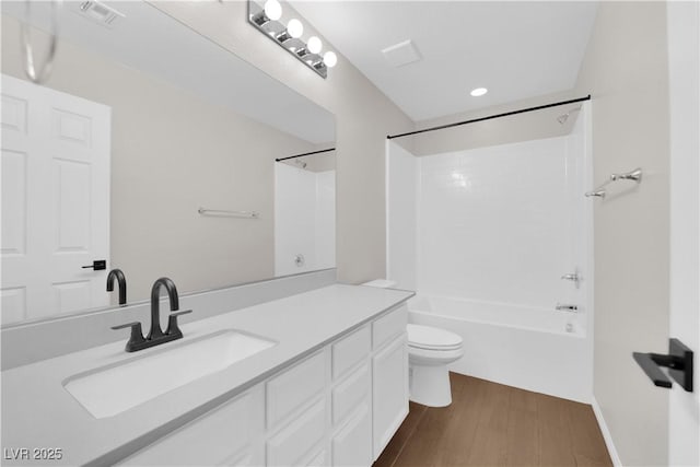 bathroom with vanity, toilet, shower / bath combination, wood finished floors, and visible vents