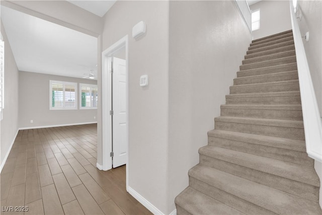 stairway featuring baseboards and wood finished floors