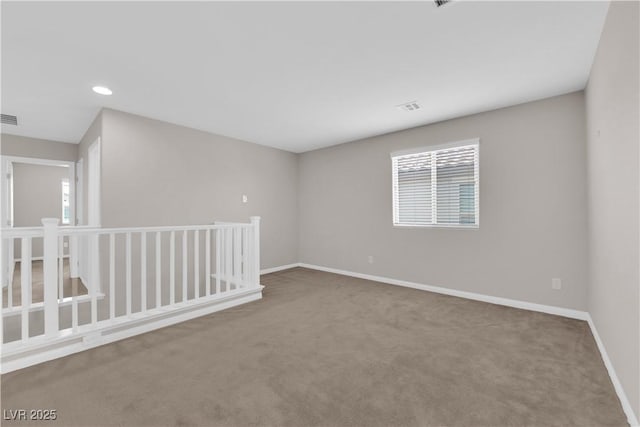 carpeted spare room featuring baseboards, recessed lighting, and visible vents