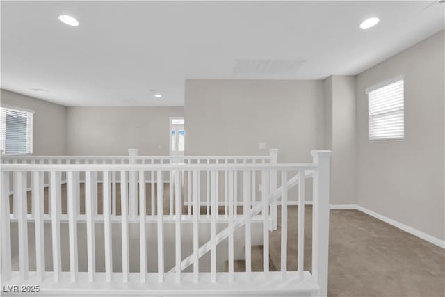 interior space with baseboards, a wealth of natural light, carpet, and visible vents