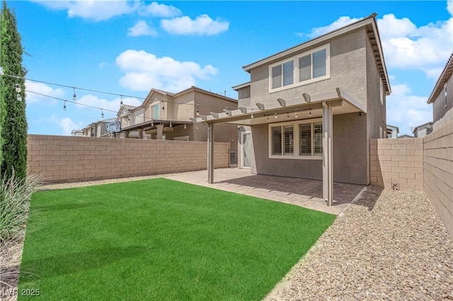 rear view of property featuring a fenced backyard, a patio, stucco siding, and a lawn
