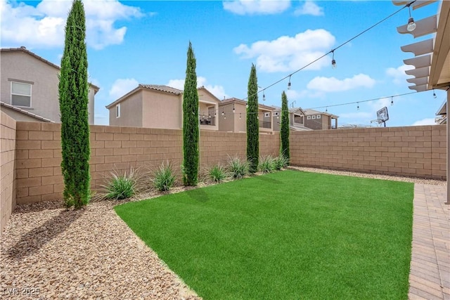 view of yard featuring a fenced backyard and a residential view