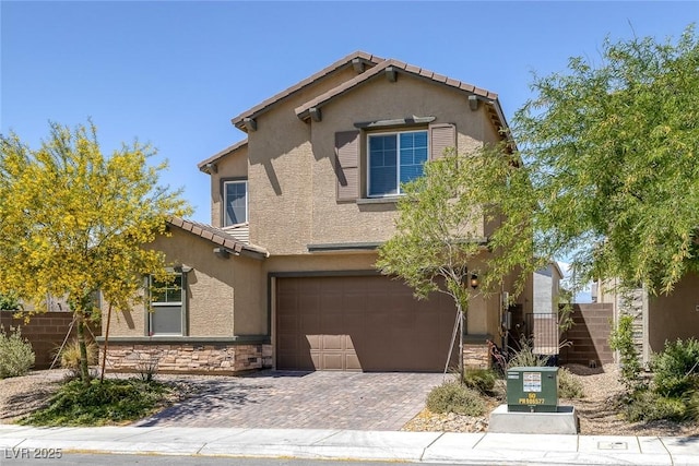 view of front of home featuring a tiled roof, a garage, decorative driveway, stone siding, and stucco siding