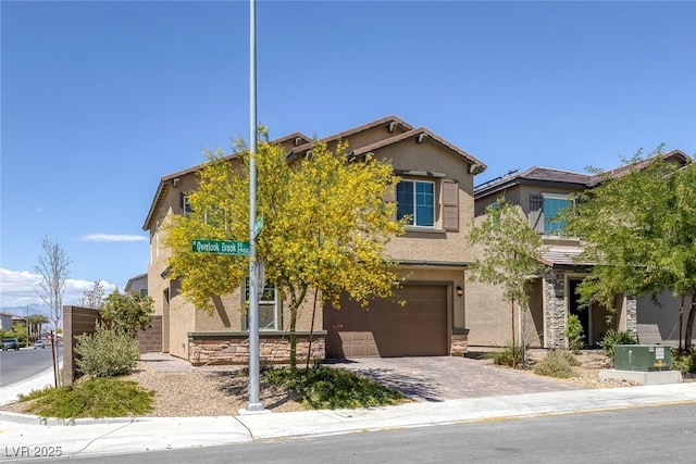 view of front of house featuring stucco siding, driveway, stone siding, and a garage