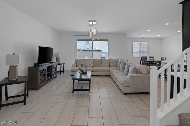 living room featuring recessed lighting, a notable chandelier, and stairway