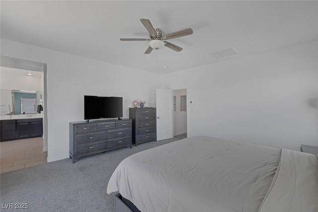 carpeted bedroom featuring baseboards, ensuite bathroom, ceiling fan, and visible vents