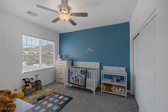 carpeted bedroom with visible vents, a ceiling fan, and baseboards