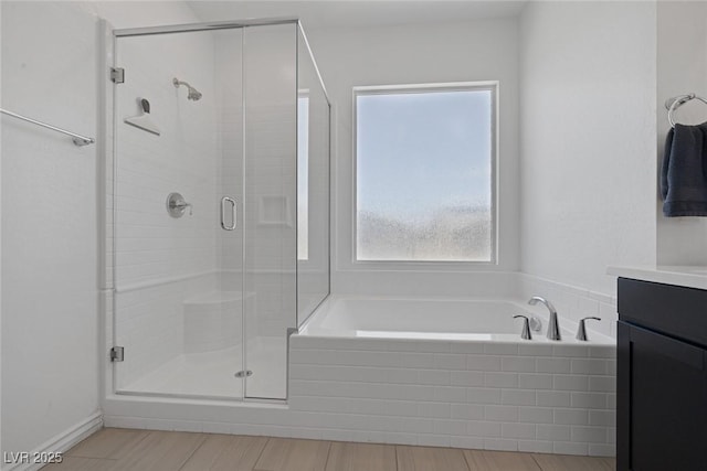 bathroom with vanity, a bath, and a shower stall