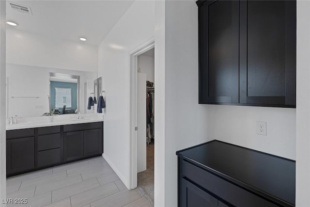 interior space with visible vents, a sink, baseboards, and recessed lighting