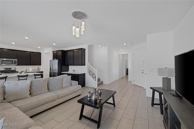 living room with recessed lighting, stairs, baseboards, and a chandelier