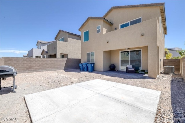 rear view of property with a fenced backyard, a patio, stucco siding, and cooling unit