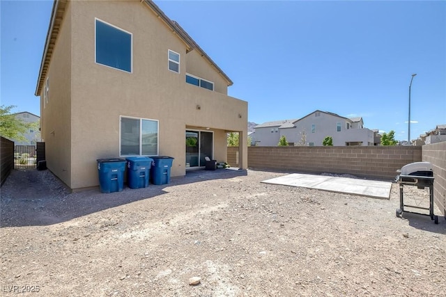 back of house featuring a fenced backyard, a patio area, and stucco siding