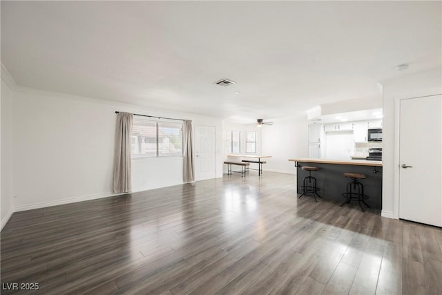 living area featuring baseboards, ceiling fan, wood finished floors, and visible vents