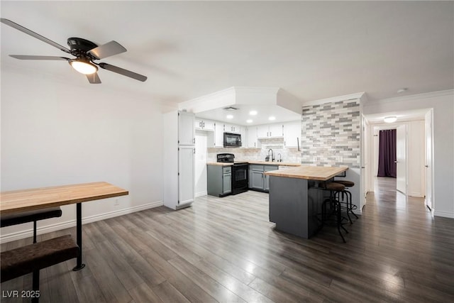 kitchen featuring decorative backsplash, ceiling fan, a sink, black appliances, and butcher block counters
