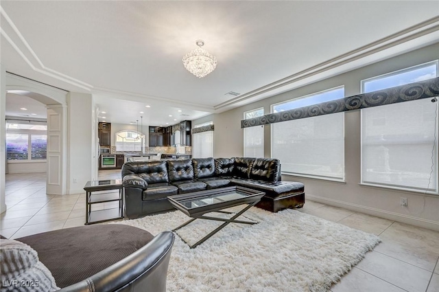 living room featuring arched walkways, baseboards, a chandelier, recessed lighting, and light tile patterned flooring