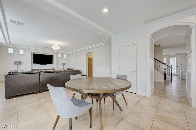 dining room featuring visible vents, decorative columns, light tile patterned flooring, stairway, and arched walkways