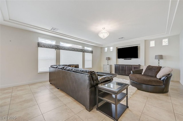 living room with baseboards, a tray ceiling, visible vents, and light tile patterned floors
