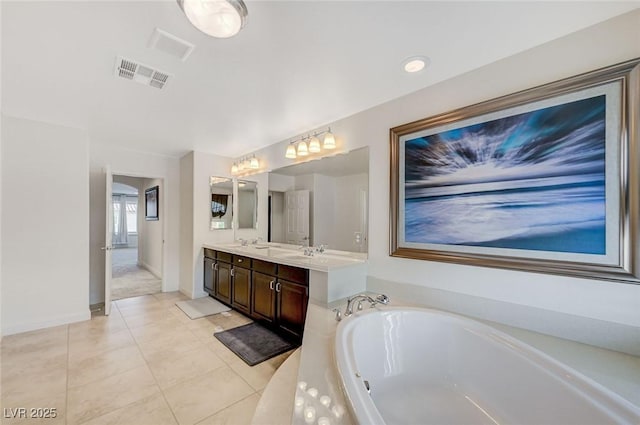 full bathroom with tile patterned flooring, double vanity, baseboards, visible vents, and a garden tub