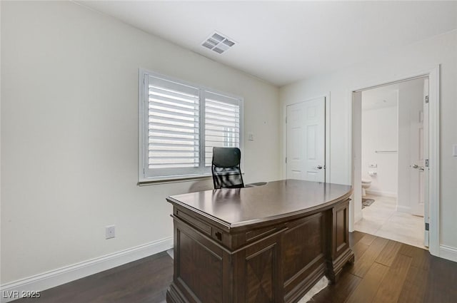 office with baseboards, dark wood-type flooring, and visible vents