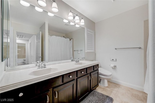 full bath featuring double vanity, a sink, tile patterned floors, and toilet