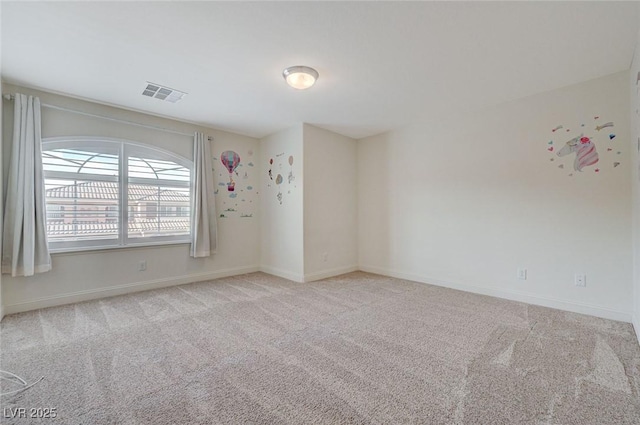 empty room with baseboards, visible vents, and carpet