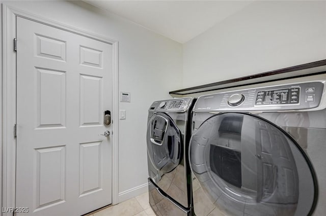 washroom with laundry area, baseboards, light tile patterned floors, and washer and dryer