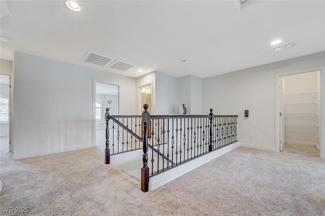 hall with carpet flooring, recessed lighting, baseboards, and an upstairs landing