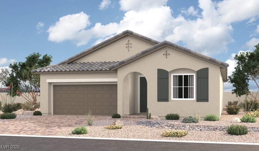 view of front facade featuring a tiled roof, stucco siding, an attached garage, and decorative driveway