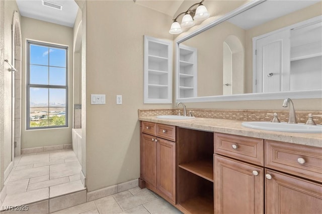 full bathroom featuring double vanity, baseboards, visible vents, and a sink