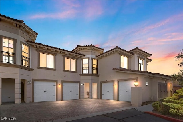 20 Via Visione Unit 105, Henderson, NV 89011 - view of front facade with an attached garage, decorative driveway, stucco siding, and a tile roof