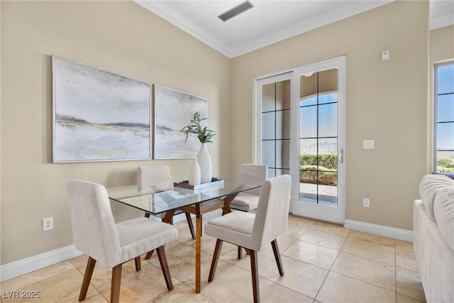dining room featuring crown molding, baseboards, visible vents, and plenty of natural light