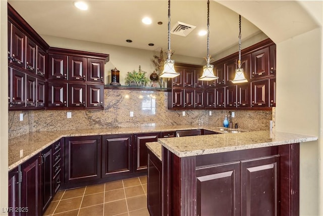 kitchen featuring visible vents, decorative backsplash, tile patterned floors, and dark brown cabinets