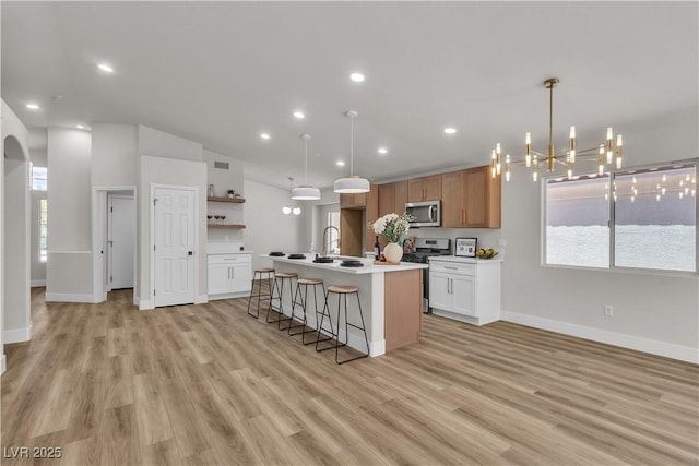 kitchen featuring baseboards, open shelves, stainless steel appliances, and light wood finished floors