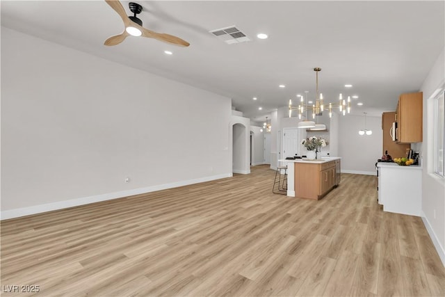 kitchen featuring visible vents, baseboards, open floor plan, recessed lighting, and ceiling fan with notable chandelier