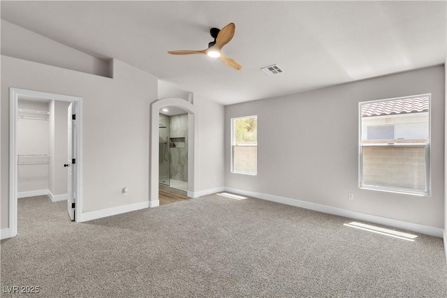 unfurnished bedroom with visible vents, carpet flooring, baseboards, and a walk in closet